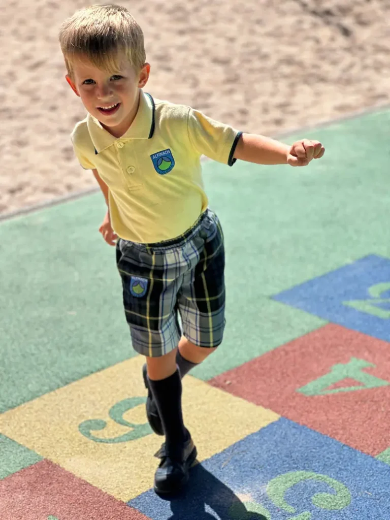 Niño de Primaria jugando en el recreo con el uniforme oficial del Colegio Alfinach.